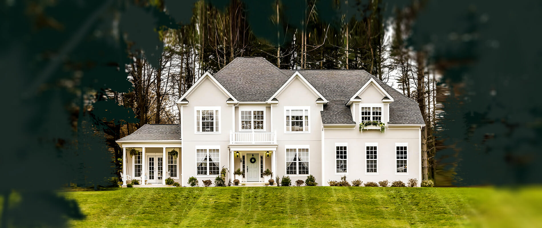 facade of custom home facade on a hill with lawn and trees